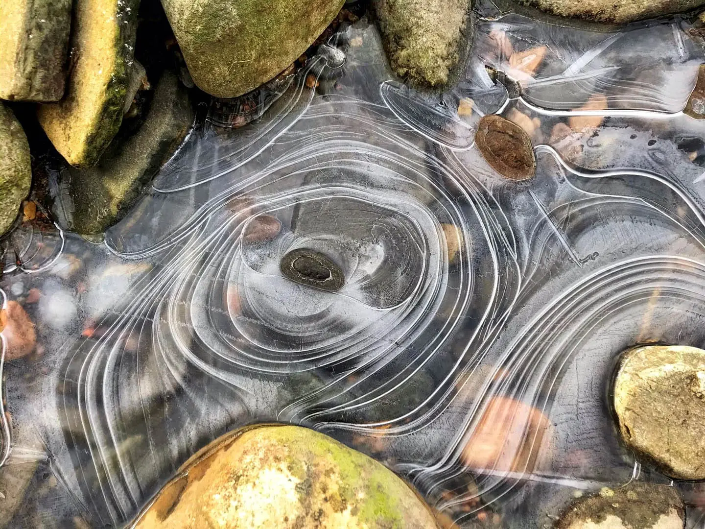 natural frozen water ripples on a shallow river stream